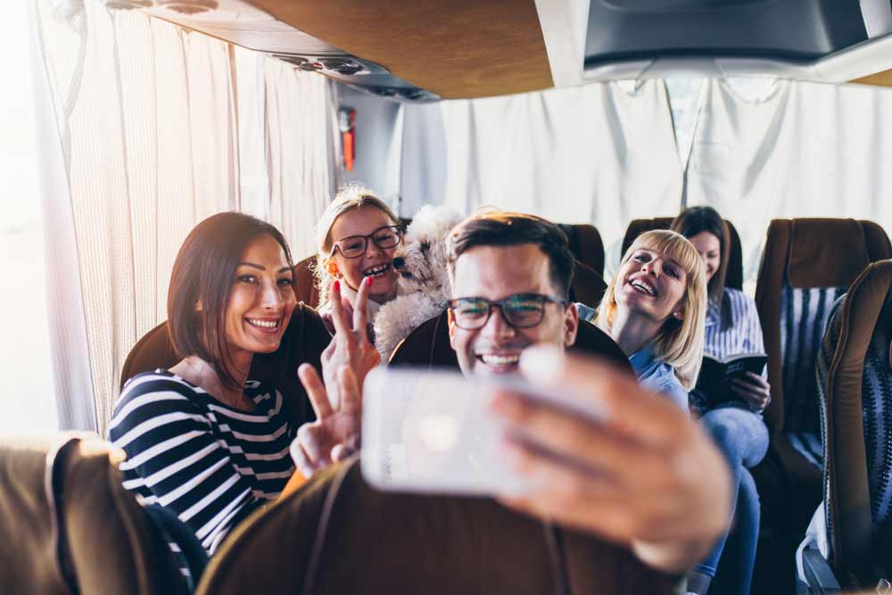 Happy Travelers Taking A Selfie Photo On A Bus